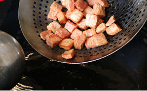 鍋上火入油300克，入煮熟改刀后將肉炸制金黃色撈出
